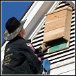 ned bruha attaching a bat box to the house on the outside of the attic vent